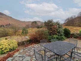 An outdoor area with a table and chairs at Deer How Farm in Patterdale near Glenridding