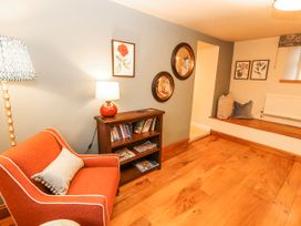 A snug with a chair and bookshelf at Deer How Farm Patterdale near Glenridding