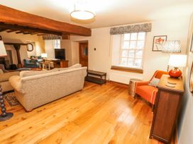 A living room with a sofa and armchair at Deer How Farm in Patterdale near Glenridding