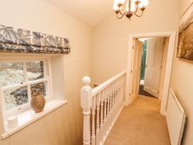 A hallway with a staircase and a window at Deer How Farm Patterdale near Glenridding