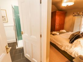 A bedroom with a bed and adjoining shower at Deer How Farm in Patterdale near Glenridding