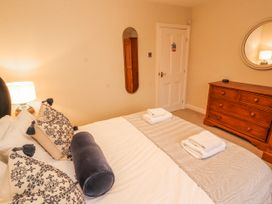 A bedroom with a bed and dresser at Deer How Farm in Patterdale near Glenridding