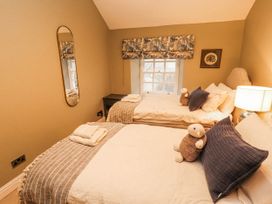A bedroom with two beds and a mirror at Deer How Farm Patterdale near Glenridding