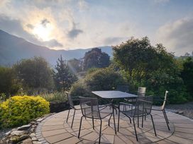 An outdoor seating area with a table and chairs at Deer How Farm Patterdale near Glenridding