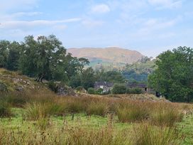 A landscape with grass and trees near a house at Deer How Farm Patterdale near Glenridding