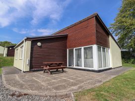 A house with a patio and table at Babbacombe Breeze in Chudleigh