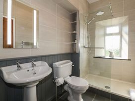 A bathroom with a sink toilet and walk in shower at Glasfryn in Llandwrog
