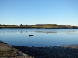 A boat on the water with buoys and trees at Glasfryn in Llandwrog