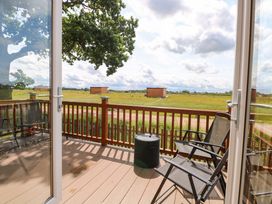 An outdoor area with chairs and a view at Oak Tree Holiday Lodge in Stonham Aspal
