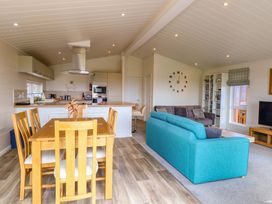 A living room with kitchen and dining area at Oak Tree Holiday Lodge Stonham Aspal