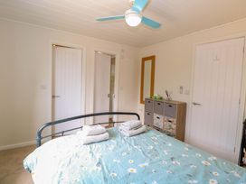 A bedroom with a bed and a cabinet at Oak Tree Holiday Lodge in Stonham Aspal