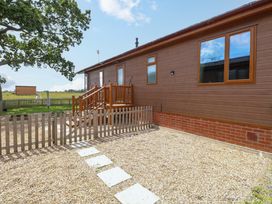 An outdoor area featuring a lodge with a wooden fence and steps at Oak Tree Holiday Lodge in Stonham Aspal