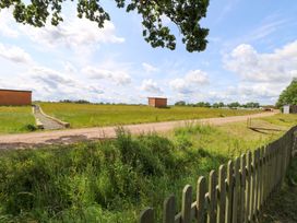 An outdoor scene with grass and a dirt path at Oak Tree Holiday Lodge in Stonham Aspal