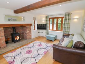 A living room with a fireplace and television at Filly Brook in Bishop's Frome
