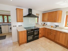 A kitchen with wooden cabinets and a cooker at Filly Brook in Bishop's Frome