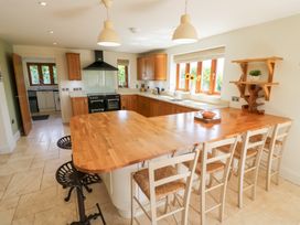 A kitchen with wooden cabinets and a bar counter at Filly Brook in Bishop's Frome