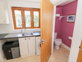 A utility room with a sink and washing machine at Filly Brook in Bishop's Frome