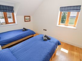 A bedroom with two beds and windows at Filly Brook in Bishop's Frome