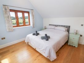 A bedroom with a bed and nightstand at Filly Brook in Bishop's Frome
