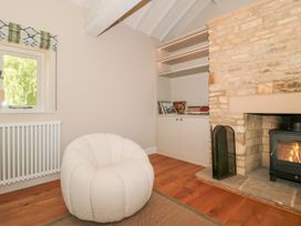 A living room with a chair and fireplace at Cleveley Mill in Enstone
