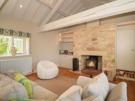 A living room with a fireplace and sofa at Cleveley Mill in Enstone