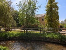 A house and trees by a stream at Cleveley Mill in Enstone