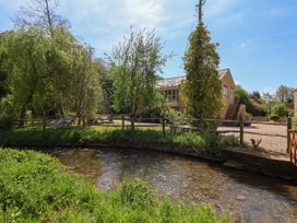 An outdoor area with a stream and trees at Cleveley Mill in Enstone