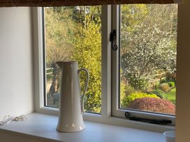 A kitchen with a pitcher and a cup on the windowsill at The Annexe, Cleveley Mill, Chipping Norton