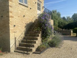 A set of stairs with flowering plants leading to a building at The Annexe, Cleveley Mill Enstone