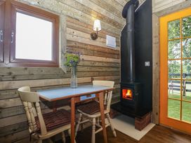 A dining area with a table and wood stove at Shepherd Hut’s in Bristol