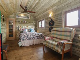 A bedroom with a bed and sofa at Shepherd Hut's in Bristol