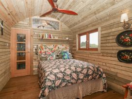 A bedroom with wooden walls and a bed at Shepherd Hut’s in Bristol