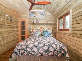 A bedroom with a bed and shelves at Shepherd Hut’s in Bristol