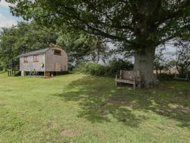 A shepherd hut with a bench and tree at Shepherd Hut’s Bristol