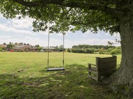 A swing and bench under a tree in an outdoor area at Shepherd Hut’s in Bristol
