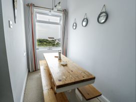 A dining room with a wooden table and chairs at Lady of the Lake Suite Trearddur Bay