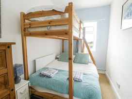 A bedroom with a bunk bed and a double bed at Lady of the Lake Suite Trearddur Bay
