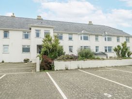 An outdoor view of a building with parking spaces at Lady of the Lake Suite in Trearddur Bay