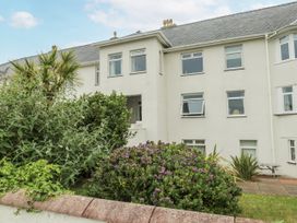 A garden view with shrubs and a building at Lady of the Lake Suite in Trearddur Bay