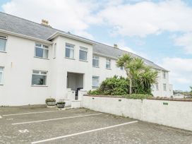 A building with windows and a palm tree at Lady of the Lake Suite Trearddur Bay