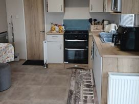 A kitchen with a stove, oven, sink and countertop at Pines 15 in Porthcawl