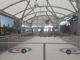 An ice rink with seating and a bar at Pines 15 Porthcawl