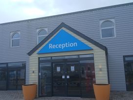 An entrance with a reception sign at Pines 15 in Porthcawl