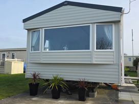 A mobile home with planters outside at Pines 15 Porthcawl