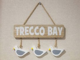 A wooden sign reading Trecco Bay with three seagull decorations at Pines 15 Porthcawl