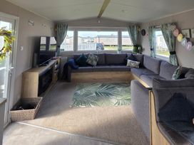 A living room with a sofa and television at Pines 15 in Porthcawl