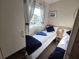 A bedroom with two single beds at Pines 15 in Porthcawl