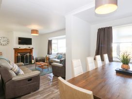 A living room with a dining table and chairs at Seabreeze in Llandudno