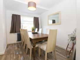 A dining room with a wooden table and chairs at Seabreeze in Llandudno