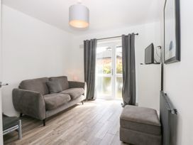 A living room with a sofa and television at Seabreeze in Llandudno
